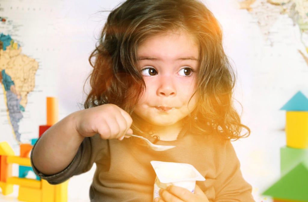 niña comiendo yogur